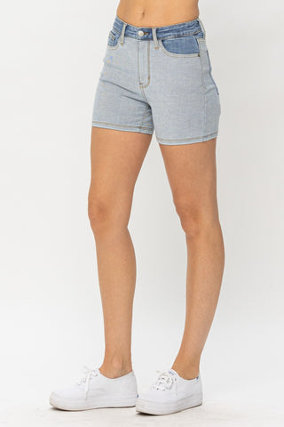 Stylish denim shorts in a versatile heather grey color, worn by a female model posing against a plain background.