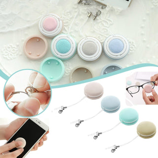 Colorful macaron-shaped screen cleaning tools on a white lace background. The image shows various pastel-colored cleaning pads designed to clean and polish device screens, including smartphones, tablets, and eyeglasses. The product placement highlights the versatile and convenient nature of these screen cleaning accessories.