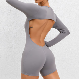 Sleek backless long sleeve gray yoga jumpsuit with open back design for modern athletic style.