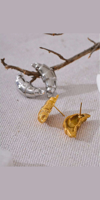 Elegant 18K gold plated croissant stud earrings on natural branch display, fashionable metal jewelry with vintage appeal.