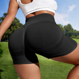 Sleek black athletic shorts with mesh panels for breathable comfort during workouts on lush green grass