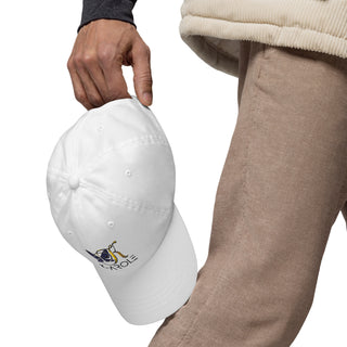 White dad hat with K-AROLE logo on it, held by person wearing casual beige pants and sweater