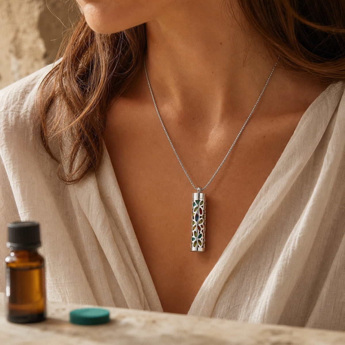 Collier diffuseur cylindrique argenté porté avec feutre parfumé