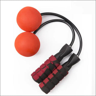 Vibrant orange fitness balls and adjustable weighted jump rope with red and black design on white background.