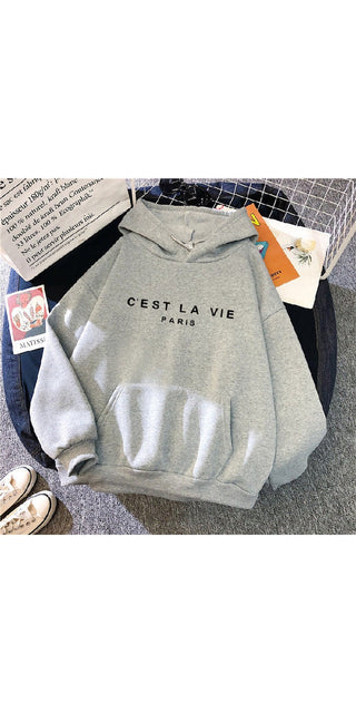 Loose hooded sweatshirt with "C'est La Vie" text print and sports shoes in the image
