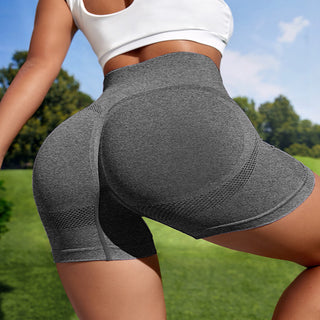 Form-fitting grey workout shorts with seamless design against a green outdoor scene