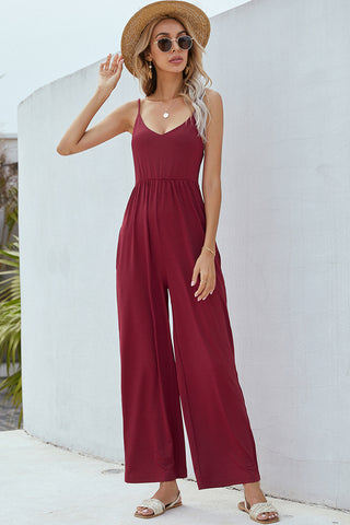 Stylish burgundy jumpsuit with wide leg design, paired with sun hat and sunglasses for a chic summer look.