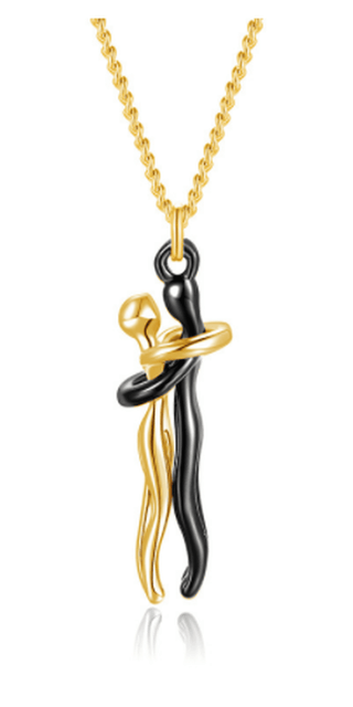 Elegant gold-toned necklace with abstract pendant design, featuring a stylized figure in contrasting colors. Fashionable unisex accessory suitable for any occasion.