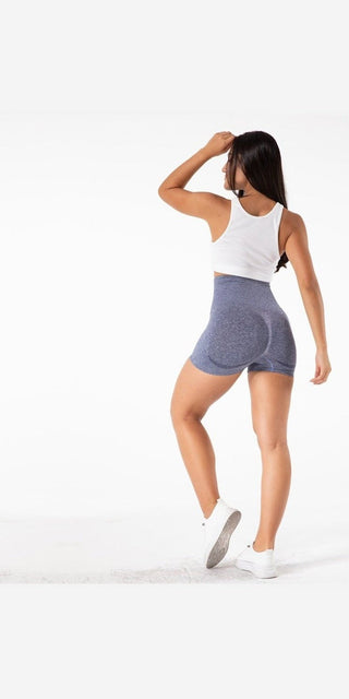 Comfortable workout attire: woman in white top and gray athletic shorts, perfect for yoga or other fitness activities.