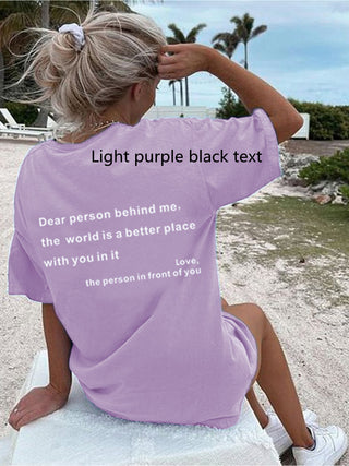 Casual woman wearing a light purple t-shirt with an inspirational message in black text