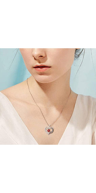 Delicate crystal heart necklace adorns the model's neck, complementing her refined style. This chic accessory adds a touch of elegance to the minimalist outfit, perfect for everyday wear.
