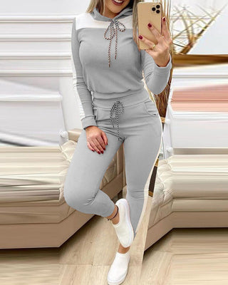 Stylish gray hooded sweatshirt and matching sweatpants set, comfortable casual activewear in modern design, woman posing and taking selfie.