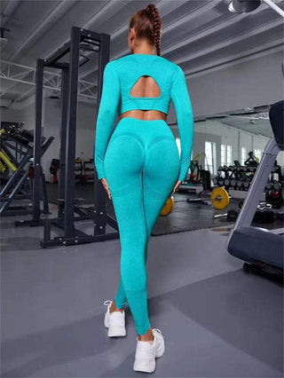 Stylish athletic outfit with seamless long-sleeve top and high-waist leggings in vibrant teal color, showcasing modern workout attire for an active lifestyle.