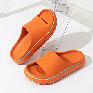 Vibrant orange slip-on sandals with a sleek, modern design. The simple and lightweight footwear is perfect for casual wear or relaxing at home. The textured rubber soles provide comfortable cushioning and traction. These trendy slippers would complement any summer outfit.