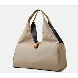 Stylish beige canvas and leather duffle bag with multiple compartments, perfect for yoga, sports, travel, and weekend getaways. The bag features a spacious main compartment, a side pocket for storage, and a minimalist design that complements any active lifestyle.