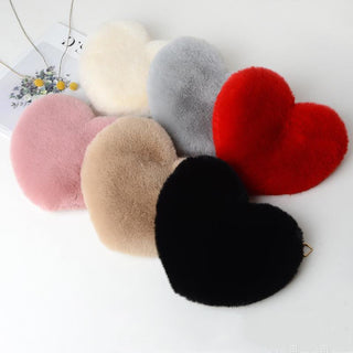 Assorted plush heart-shaped ornaments displayed on a white background. The ornaments come in various colors including pink, gray, beige, red, and black, creating a visually appealing and festive arrangement.
