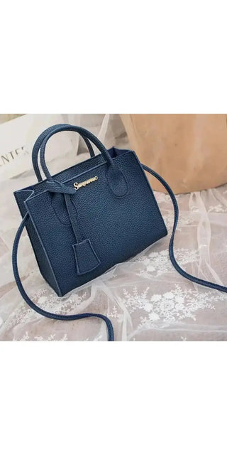 Stylish navy blue leather satchel with a detachable shoulder strap, featuring a sleek and modern design, perfect for carrying essentials while staying fashionable.
