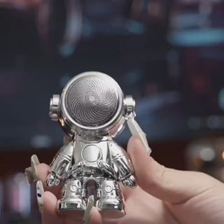 Stylish mini portable electric shaver in the shape of an astronaut, held in a person's hand against a dark background