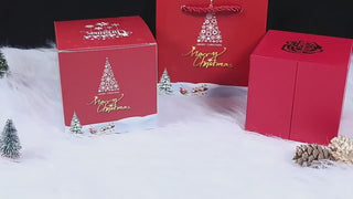 Festive Christmas gift boxes in red and gold featuring holiday imagery like Christmas trees and Santa's sleigh. Elegant and seasonal product placement against a snowy backdrop.