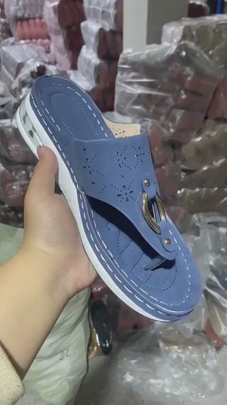 Stylish blue thong sandals with perforated design and metallic buckle accent, perfect for comfortable and fashionable summer wear.