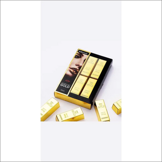 Luxury gold-colored makeup kit with lipstick and eyeshadows showcased on a plain white background.