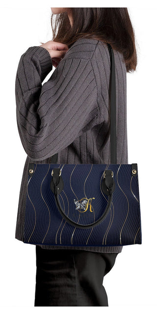 Elegant navy blue and gold quilted leather tote bag by K-AROLE, featuring a stylish and versatile design to elevate any woman's athleisure outfit.