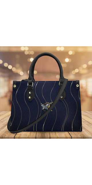 Elegant navy blue quilted leather tote bag with striking gold accents, showcased on a wooden surface with a warm, blurred background from K-AROLE.