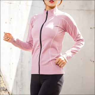 Slim fit pink sportswear with zipper detail, worn by a woman against a white background