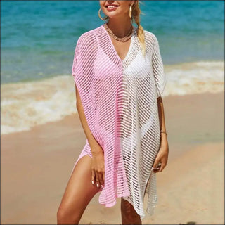 Stylish knit beach cover-up with gradient pink and white design, worn over a swimsuit on the beach by a smiling woman.