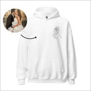 A white hooded sweatshirt with a minimalist graphic design of two embracing figures printed on the front, against a plain white backdrop.