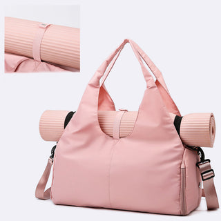 Stylish pink yoga bag with strap for carrying yoga mats. Dual compartment design for separating dry and wet items. Durable and spacious sports fitness travel bag.