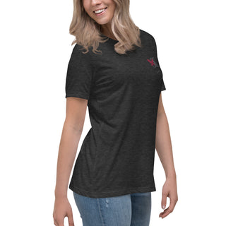 Relaxed black t-shirt with small logo on front, worn by a smiling young woman with long blonde hair against a white background.