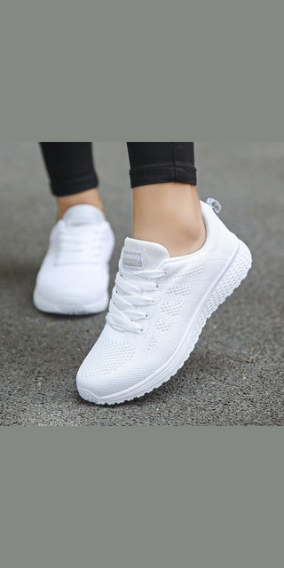 Comfortable white mesh women's sneakers for casual walking and gym activities, displayed on a grey background.