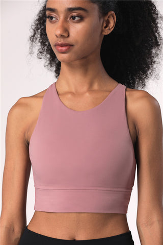 Supportive pink crop top from K-AROLE featuring a cross-back design, ideal for yoga and other fitness activities.