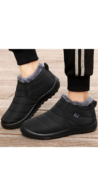 Stylish black winter boots with fur lining for women. Durable, non-slip soles provide stability and traction in cold weather conditions. Comfortable and warm shoes perfect for casual everyday wear or outdoor activities.