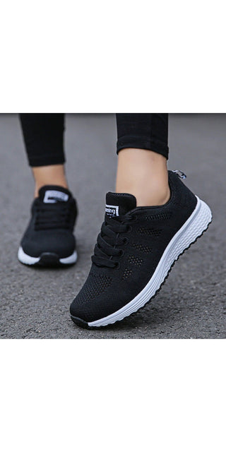 Sleek black mesh sneakers with lace-up closure for a sporty, comfortable women's casual footwear. The breathable design and flat sole make these ideal for everyday walking and gym workouts.