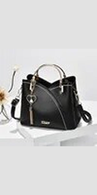 Stylish black women's purse with leather texture and tassel details. Spacious tote bag with dual handles and adjustable strap for versatile wear.