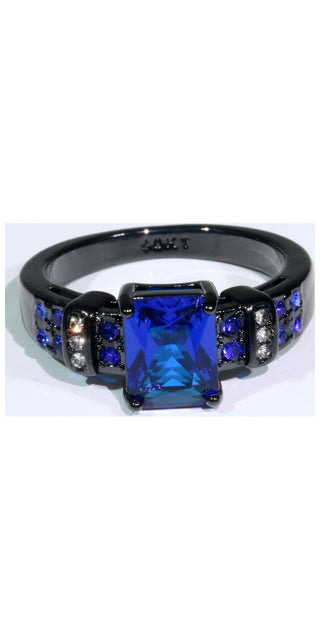 Elegant blue crystal ring with black metal band and sparkling accents. Fashionable women's jewelry accessory showcased on a plain white background.
