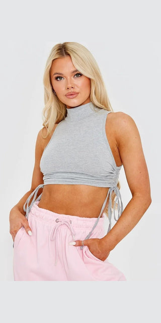 Elegant gray cropped top with side-tie detail showcased on a model with blonde hair against a white background.