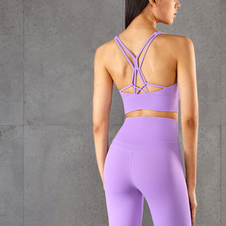 Stylish lavender sports bra with criss-cross straps and matching leggings, ideal for yoga or other fitness activities.