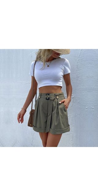 Fashionable casual green shorts with belt for women, stylish white crop top, straw hat, minimalistic background