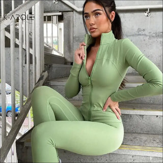 Fitted green legging and jacket set by K-AROLE™️, featuring a stylish woman modeling the athletic outfit against an urban backdrop.