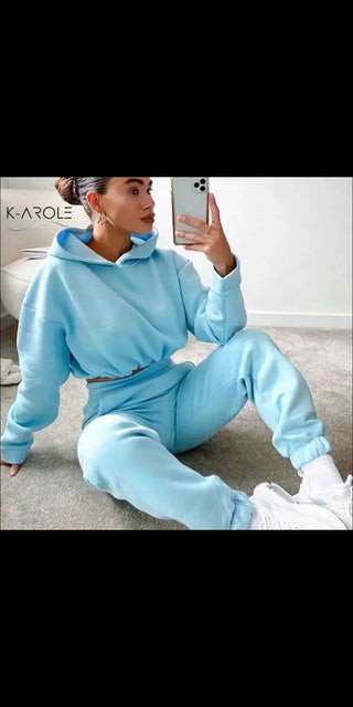 Comfortable blue women's two-piece K-AROLE™️ jogging suit with hoodie and leggings, showcased on a model posing with a smartphone.