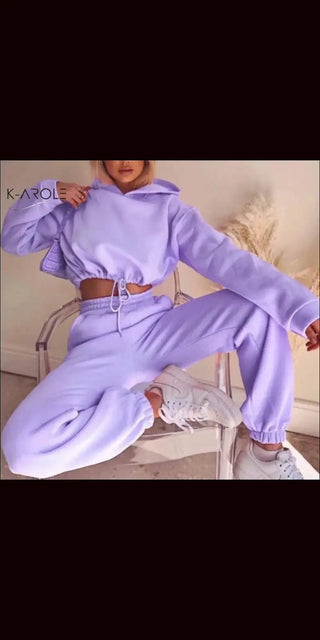 Soft lavender colored 2-piece jogging suit with hooded sweatshirt and matching leggings from K-AROLE brand, displayed on a chair against a dark background.