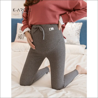 Stylish maternity leggings from K-AROLE, a premier women's fashion brand, featured on a relaxed bedroom setting.