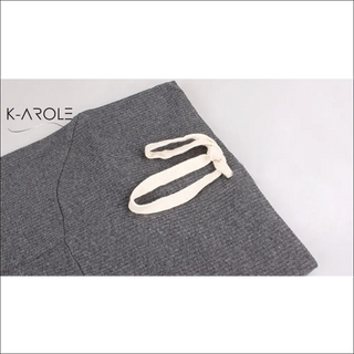 Trendy maternity leggings from K-AROLE with stylish logo detail on a gray fabric background.