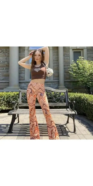 Stylish woman wearing a trendy printed jumpsuit posing outdoors near a brick building