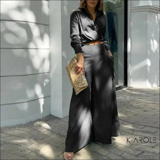 Elegant fashionable woman's black maxi dress with pockets, K-AROLE apparel brand logo visible
