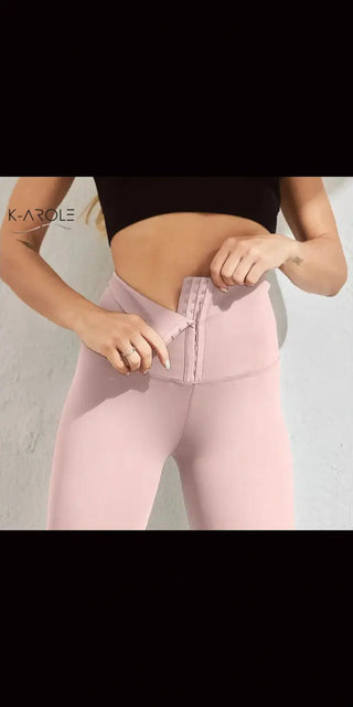 Stylish pink leggings with subtle branding, showcasing a slim, athletic silhouette.