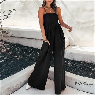 Elegant black women's jumpsuit with a smocked bodice and wide, flowing legs, showcased in a K-AROLE store display.